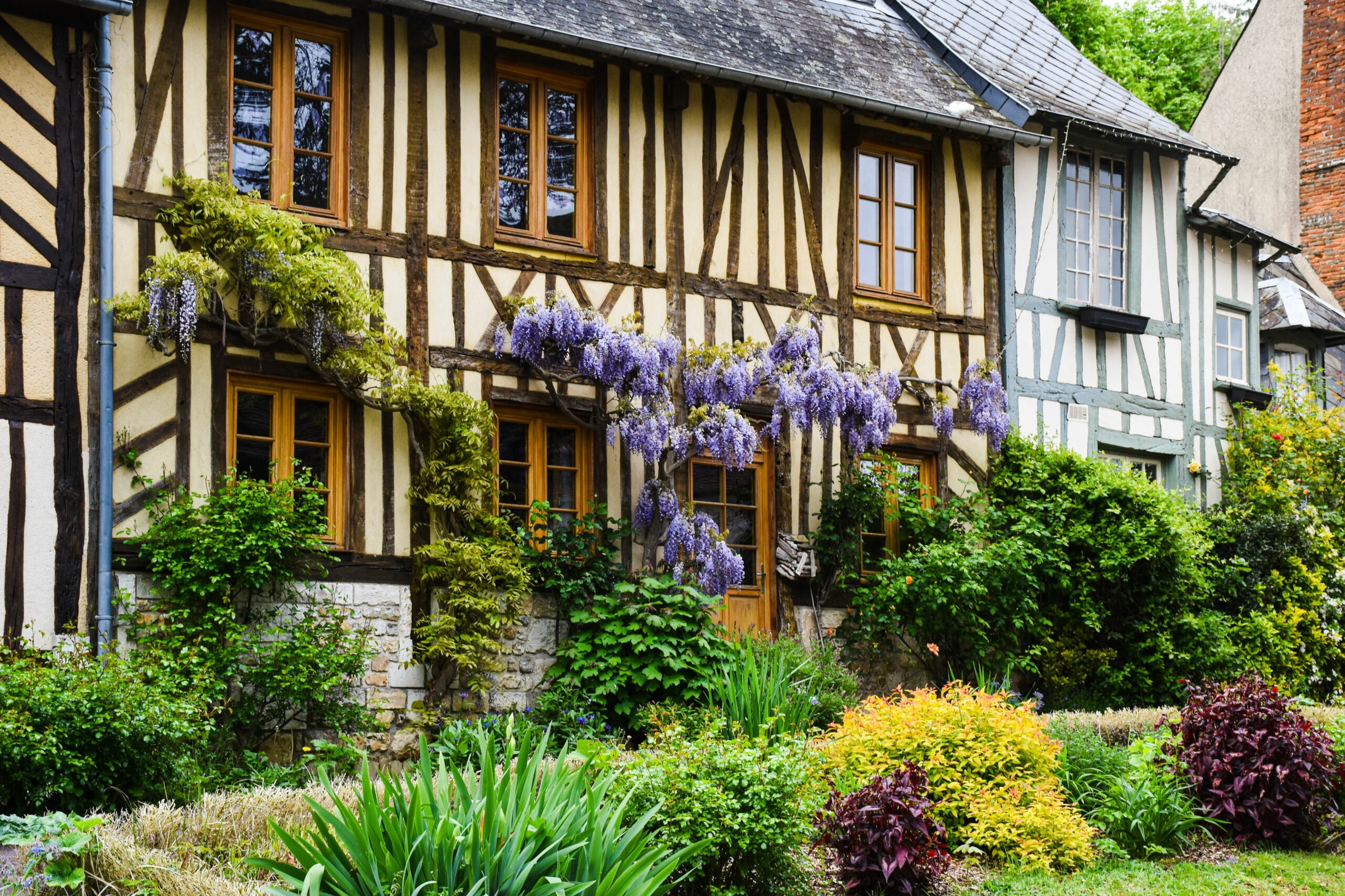 Picturesque half-timbered house with lush garden in Normandy, France.